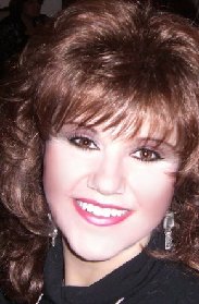 A woman with brown hair and big smile.