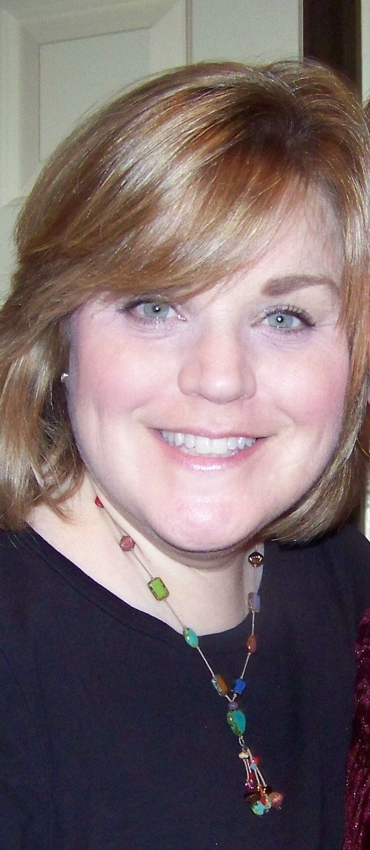 Smiling woman with short blonde hair.