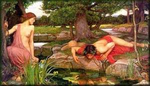 Man gazing at reflection in forest stream.