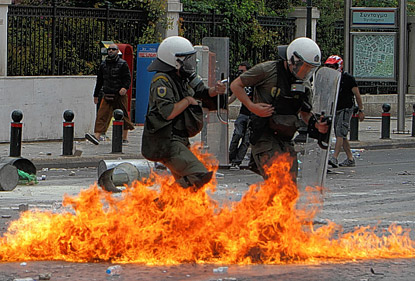 Two police officers running through a fire.