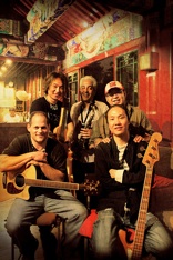 A group of people with guitars in front of a building.