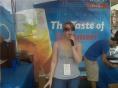 Person singing at outdoor event booth.