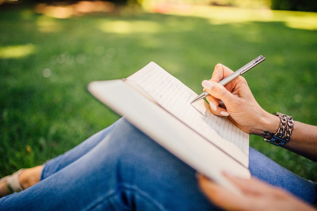 Photo of a woman writing outside